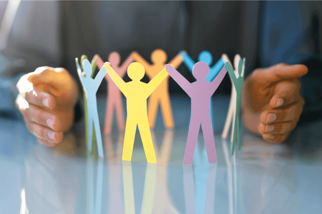 Human paper-figure cutouts holding hands in a circle, representing community and support of the growth support membership